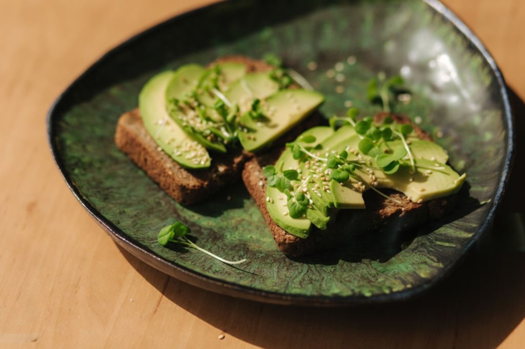 Tostadas de aguacate con microgreens en un plato de cerámica